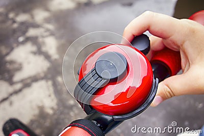 Child hand ringing bicycle bell outside. Stock Photo