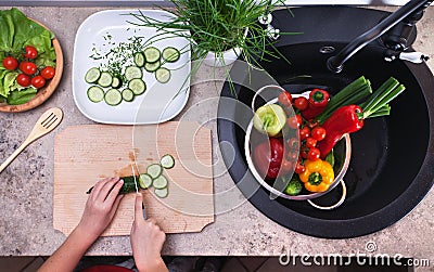 Child hands chopping vegetables on cutting board - slicing the c Stock Photo