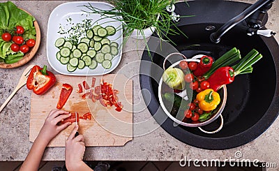 Child hands chopping vegetables for a salad - top view Stock Photo