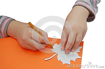 Child hands draws a leaf with pencil and stencil Stock Photo