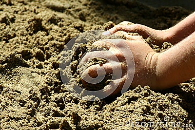 Child hands grabbing sand on a beach Stock Photo