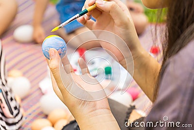 Child hands painting Easter eggs with family Stock Photo