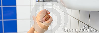 child hands using air dryer in public toilet or washrooms. banner. Stock Photo