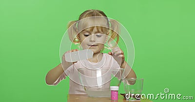 Child having fun making slime. Pour the glue. Kid with hand made toy Stock Photo