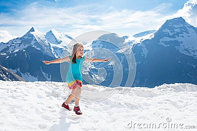 Child hiking in mountains. Kids in snow in spring Stock Photo