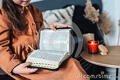 The child in his hands holds the Bible close-up Stock Photo