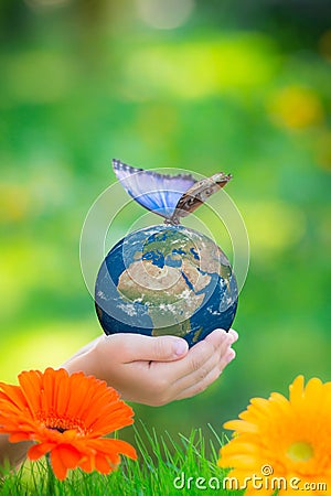 Child holding Earth planet with blue butterfly in hands Stock Photo