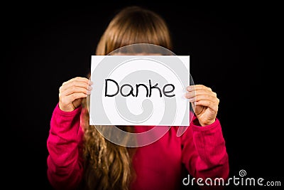 Child holding sign with German word Danke - Thank You Stock Photo