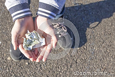 A child holds coins and euro notes in his hands. Pocket money image Stock Photo