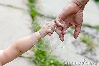 Child holds the finger of a hand Stock Photo