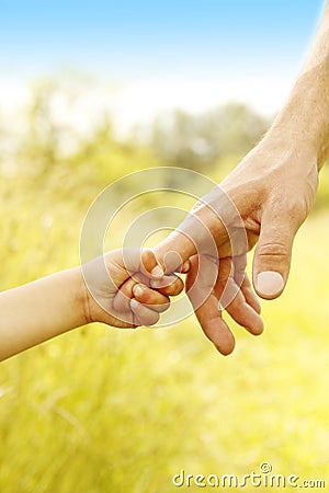 Child holds the hand of parent Stock Photo