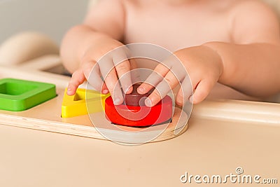 Child at home is manipulating montessori material to learn. Close up. Side view. Stock Photo