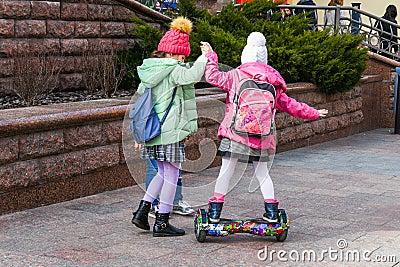 Child on hover board. Kids riding scooter in summer park. Balance board for children. Electric self balancing scooter on city Editorial Stock Photo