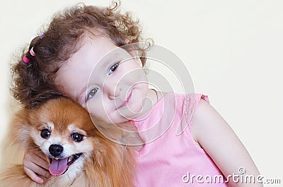 Child hugs his dog with love. childhood friends. happy girl and pomeranian Stock Photo