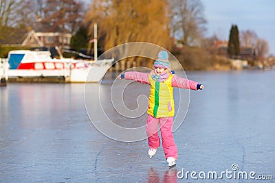 Child ice skating on frozen mill canal in Holland. Stock Photo