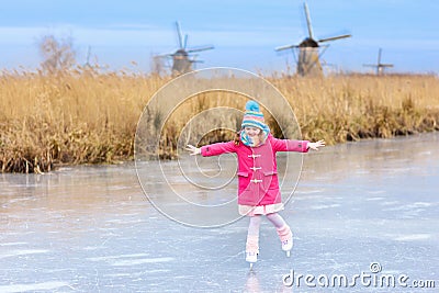 Child ice skating on frozen mill canal in Holland. Stock Photo