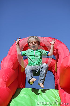 Child on inflatable bouncy castle slide Stock Photo