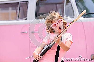 Child jumping, excited little rock guitarist with guitar. Stock Photo