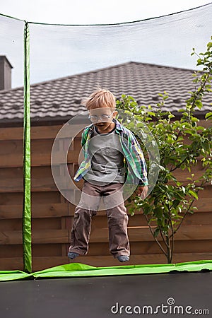 Child jumping on trampoline in the backyard Stock Photo