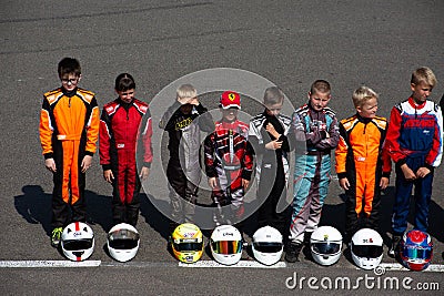 Child kart racers line up next to their helmets at the competition Editorial Stock Photo