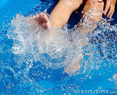 Child kicking in pool Stock Photo