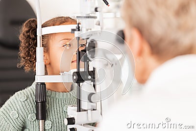 Child, kid or girl in optometry eye exam with optometrist, ophthalmologist or consulting medical profession and clinic Stock Photo