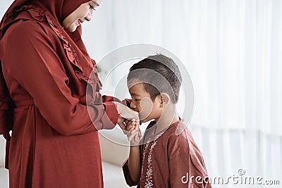 Child kissing his mother`s hand to apologize Stock Photo