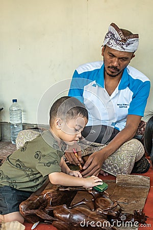 Child labor at Sari Pertiwi Wood Carving business, Juga, Bali, Indonesia Editorial Stock Photo