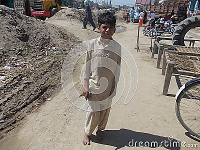 Child labour - small boy going for day work in Pakistani Village Editorial Stock Photo