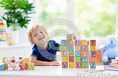 Child learning letters. Kid with wooden abc blocks Stock Photo