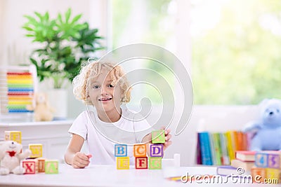 Child learning letters. Kid with wooden abc blocks Stock Photo