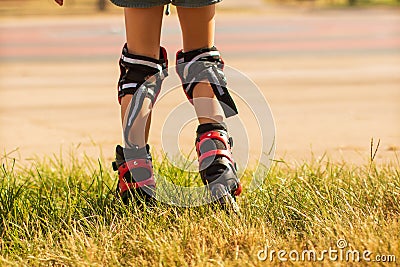 Child learns to ride roller skates, children`s legs in roller skates and knee-lengths from the back Stock Photo