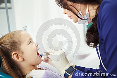 Child lies in dentist chair and goes through procedure Stock Photo