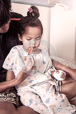 Child little girl gets medicine with a syringe in her mouth Stock Photo