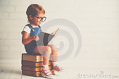 Child little girl with glasses reading a books Stock Photo