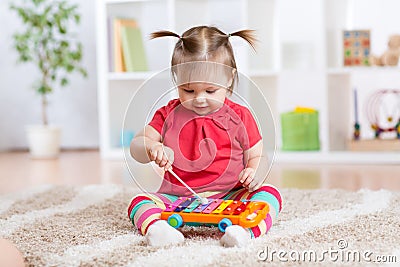 Child little girl plays a musical instrument Stock Photo