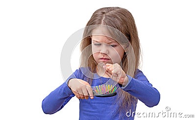 Child with long hair pulling out hair from brush Stock Photo