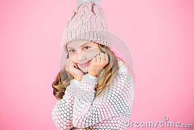 Child long hair warm woolen hat enjoy warm and softness. Kid girl wear knitted warm hat relaxing pink background. Warm Stock Photo