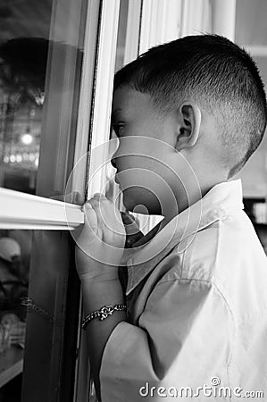 Child looking through a window, child longing Stock Photo