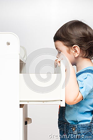 Child looks in a chest of drawers Stock Photo