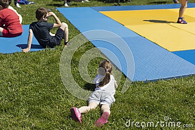The child is lying on the grass. A girl at a sporting event Editorial Stock Photo