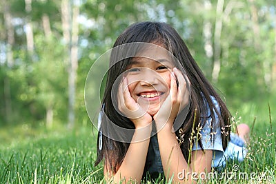 Child lying on grass smiling Stock Photo