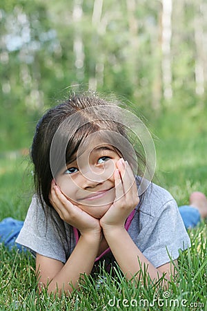 Child lying on grass smiling Stock Photo