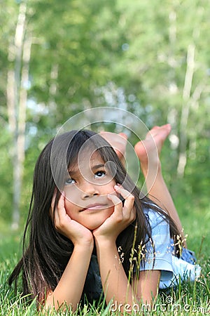 Child lying on grass thinking Stock Photo