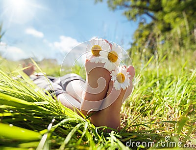 Child lying in meadow relaxing in summer sunshine Stock Photo