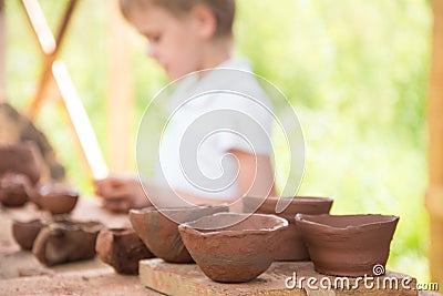 The child makes dishes and various figures from clay. Pottery skills. Hobbies and interests. Children`s education Stock Photo