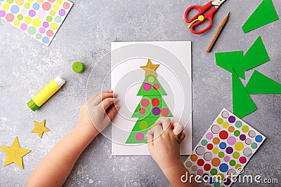 The child makes a greeting card Christmas paper collage. Children`s art project craft for kids Stock Photo