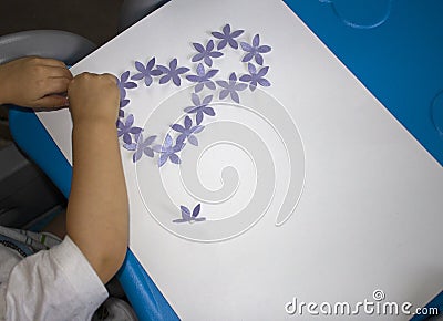 Child making postcard with picture 8 march. Kid paperwork. Material for creativity. Kindergarten Stock Photo