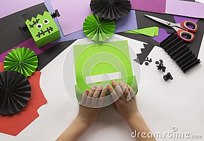 A child making decorum of Halloween from colored paper. Stock Photo