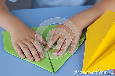 Child making a paper plane Stock Photo